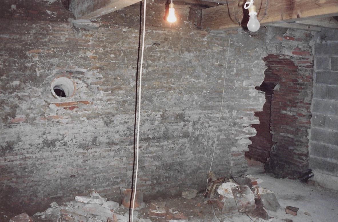 Vue du fond de la salle vers la scène — le mur en briques là où se trouve aujourd'hui le petit balcon